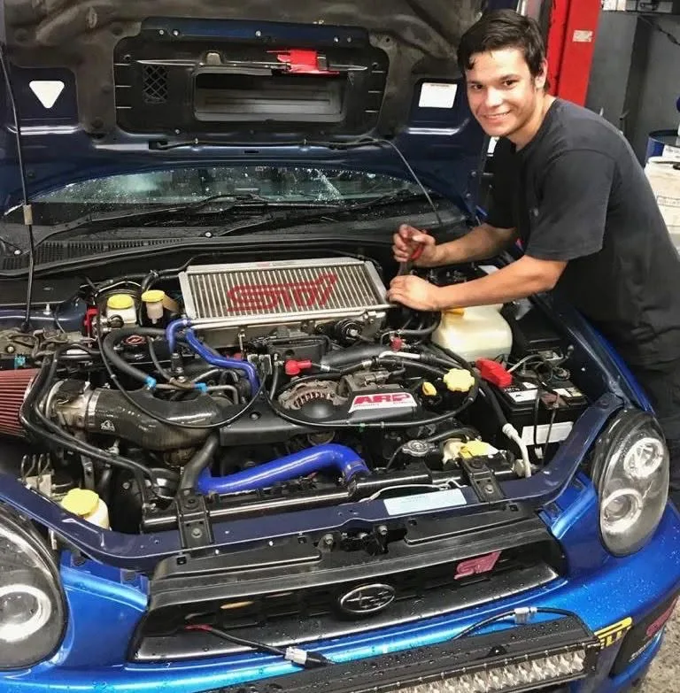 Licensed mechanic working on an engine bay at City Service Mechanics